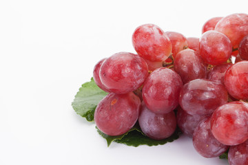 Ripe red grape with leaves isolated on white