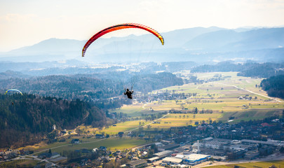 Two paragliders are flying in the valley.