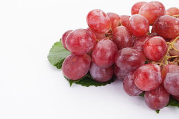 Ripe red grape with leaves isolated on white