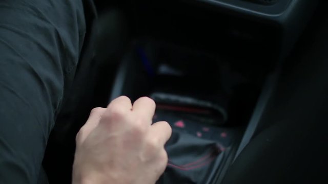 man hand switching a manual gear shift in the car