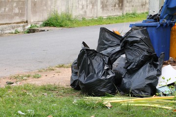 Pile black garbage bag roadside in the city