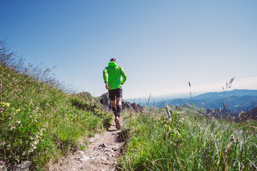 Man trail running on a mountain in summer
