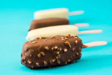 Chocolate ice cream popsicles isolated on blue background. 
