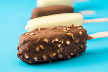 Chocolate ice cream popsicles isolated on blue background. 
