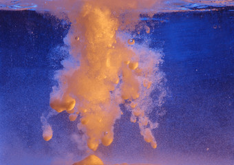 Abstract background with blue and orange colors. Splash when the powder hits the water.
