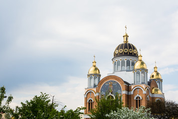 Fototapeta na wymiar New orthodox church with golden domes in spring, build in 1990's in Kiev, the capital of Ukraine