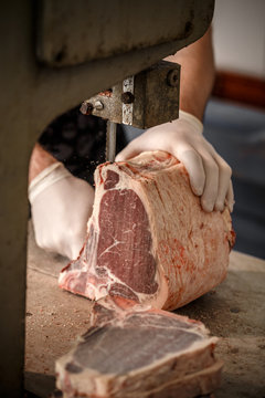 Male butcher's hand slicing meat