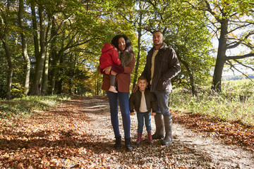 Portrait Of Family On Autumn Walk In Woodland Together