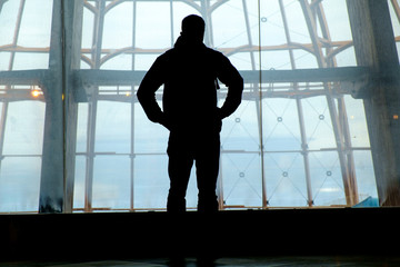 Fototapeta na wymiar Silhouette of man standing over window