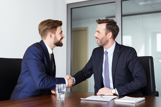 Job interview handshake - two businessmen shaking hands after successful recruitment