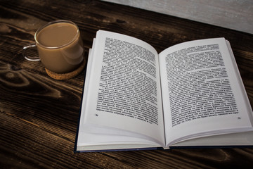 Naklejka na ściany i meble opened book and coffee on wooden background