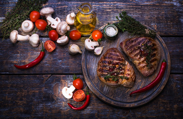  Beef Steak, salt, pepper, garlic, rosemary, olive oil  on the black wooden board, background.