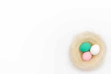 nest with colored Easter eggs on a white background.