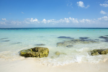 The Caribbean sea and the beautiful beach. Small waves hitting the shore on a sunny day.