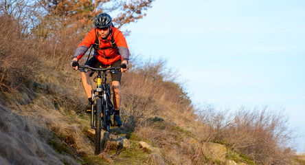 Enduro Cyclist Riding the Mountain Bike on the Rocky Trail. Extreme Sport Concept. Space for Text.