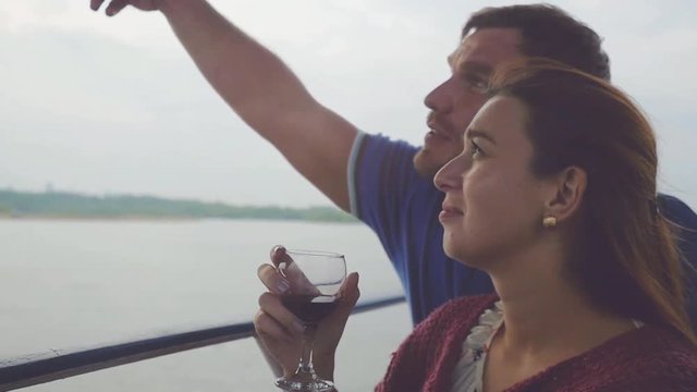 Young romantic couple rest on a yacht, drink wine in slow motion. 1920x1080