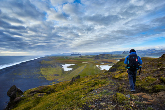 A man walking on top of Dyrholaey, Iceland