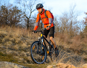 Enduro Cyclist Riding the Mountain Bike on the Rocky Trail. Extreme Sport Concept. Space for Text.