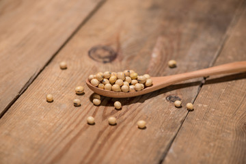 Obraz na płótnie Canvas Soya beans in spoon on wooden table.