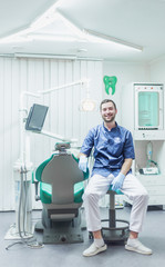 Portrait of a dentist. Young man at his workplace in the dental clinic