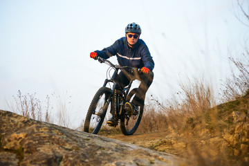Naklejka premium Enduro Cyclist Riding the Mountain Bike on the Rocky Trail. Extreme Sport Concept. Space for Text.
