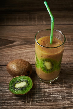 Healthy fresh kiwi smoothie in glass on a wooden background