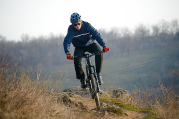 Fototapeta premium Enduro Cyclist Riding the Mountain Bike Down Beautiful Rocky Trail. Extreme Sport Concept. Space for Text.