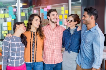 Smiling executives standing with arms around