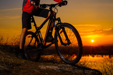 Enduro Cyclist Riding the Mountain Bike on the Rocky Trail at Sunset. Active Lifestyle Concept.