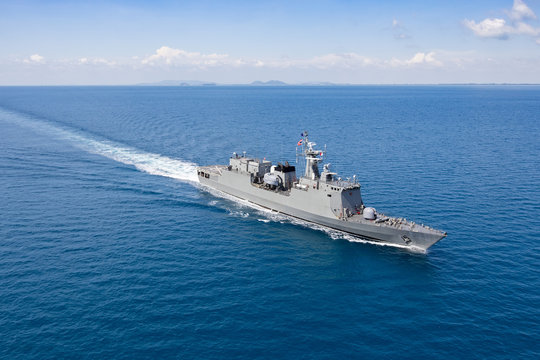 Grey modern warship, helicopter view
