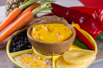 Bowl of spicy vegetable yellow curry sauce and all the ingredients that go into making it.  Used widely in Indian food.