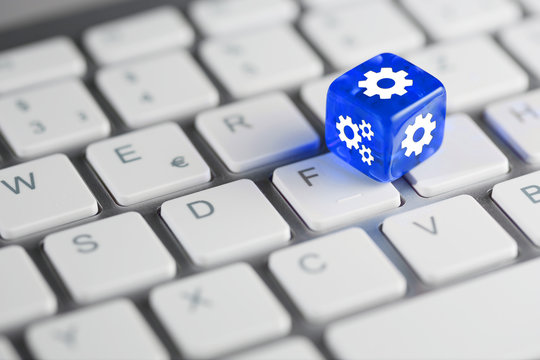 Blau farbener / blauer W&uuml;rfel auf Tastatur mit Zahnr&auml;der / Einstellungen Setup Konfiguration
