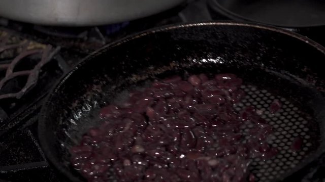 Red kidney beans frying in a pan