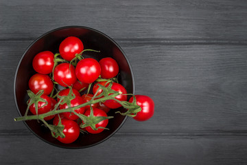 Ripe cherry tomatoes in bowl on wood board. Copy space - 141357776