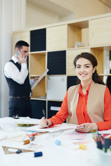 Stylish female looking at camera while working in fashion studio