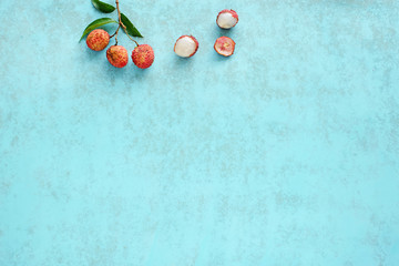Naklejka na ściany i meble Bunch of fresh lychee (litchi, liche) on a blue background. Space for text. Top view.