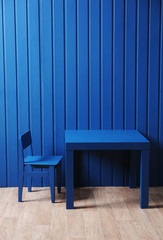 Blue table and chair near the blue wall