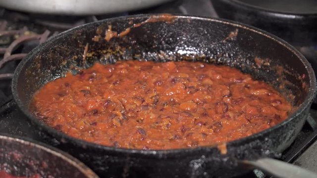 Beans frying in the pan in tomat sauce