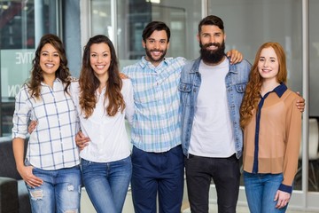 Obraz premium Portrait of male and female executives standing arms around