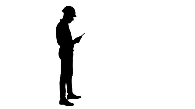 Silhouette Contractor engineer inspecting construction site holding digital tablet