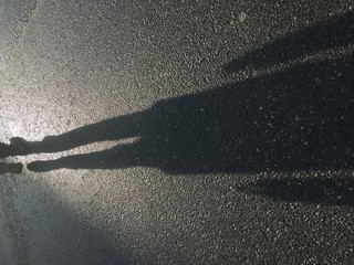 Shadow of a man walking on street concrete background 