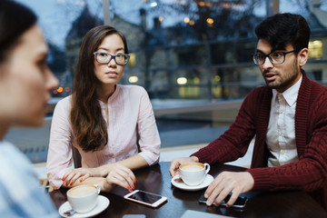 Modern managers having conversation in cafe after work
