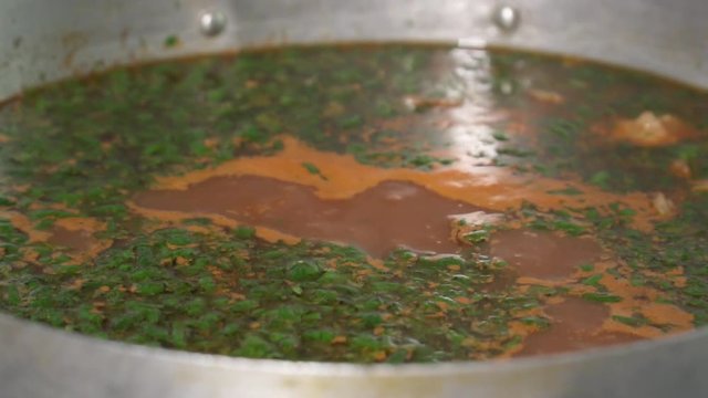 Closeup of the boiling soup with dill, slow motion