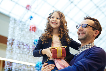 Happy man and his daughter saw something interesting during walk in shopping center