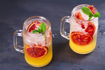Bloody orange cocktail garnished with mint in the jars