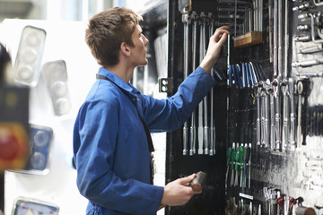 College mechanic student selecting tools from repair garage tool kit