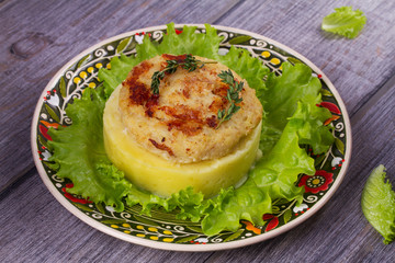 Fish patty with mashed potato and lettuce. View from above, top studio shot