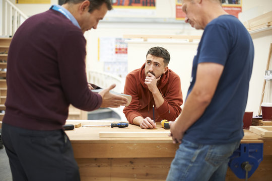 Man explaining carpentry technique in carpentry class