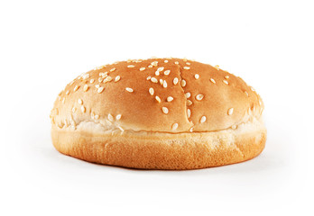 Hamburger bun with sesame seeds isolated on white background. Front view.
