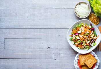 Salad of chicken breast with zucchini and cherry tomatoes, on a wooden background